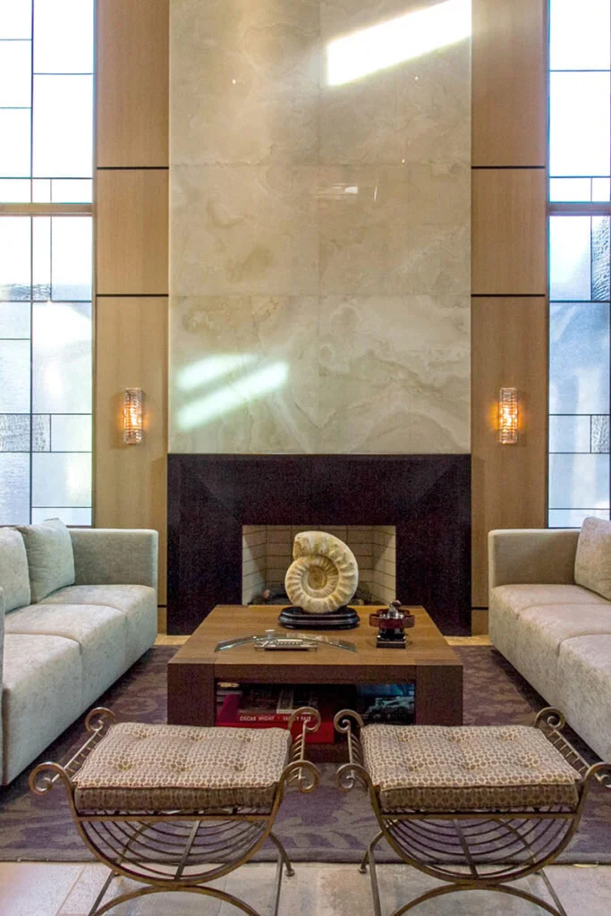 Dark paneled contemporary fireplace topped with swirling marble.