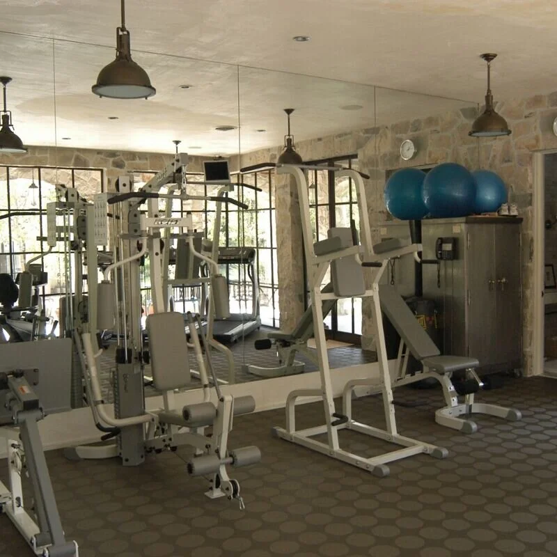 A photograph of a home gym with exercise equipment in front a wall to floor ceiling. A room idea for when the kids move out.