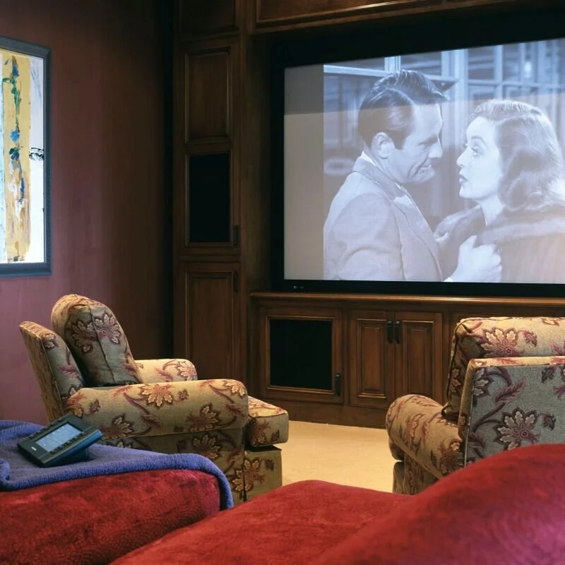 Photograph of a home theatre with large screen and comfortable seating. A room idea for when the kids move out.