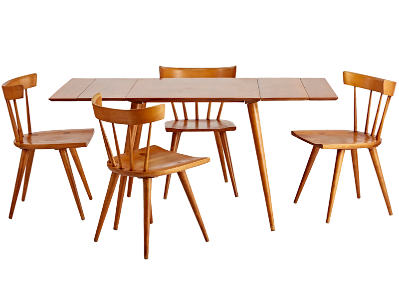 A dining table set by Paul McCobb.  The natural wood shines through on this set that has tapered table and chair legs and a minimalistic style.