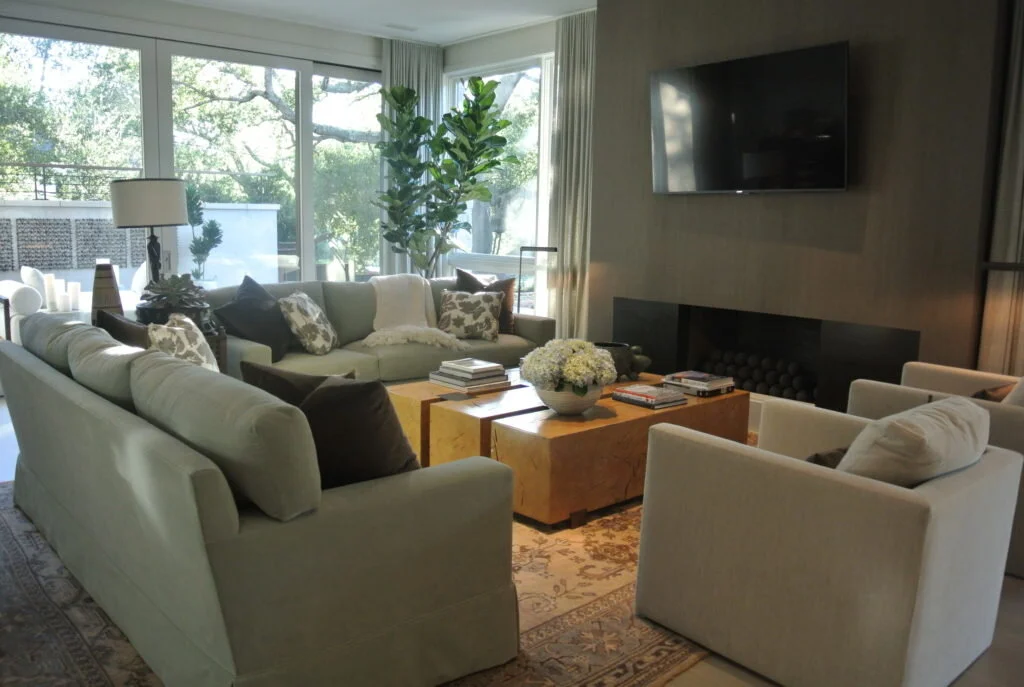 A living room with upholstered sofas and chairs arranged around a wooden coffee table.