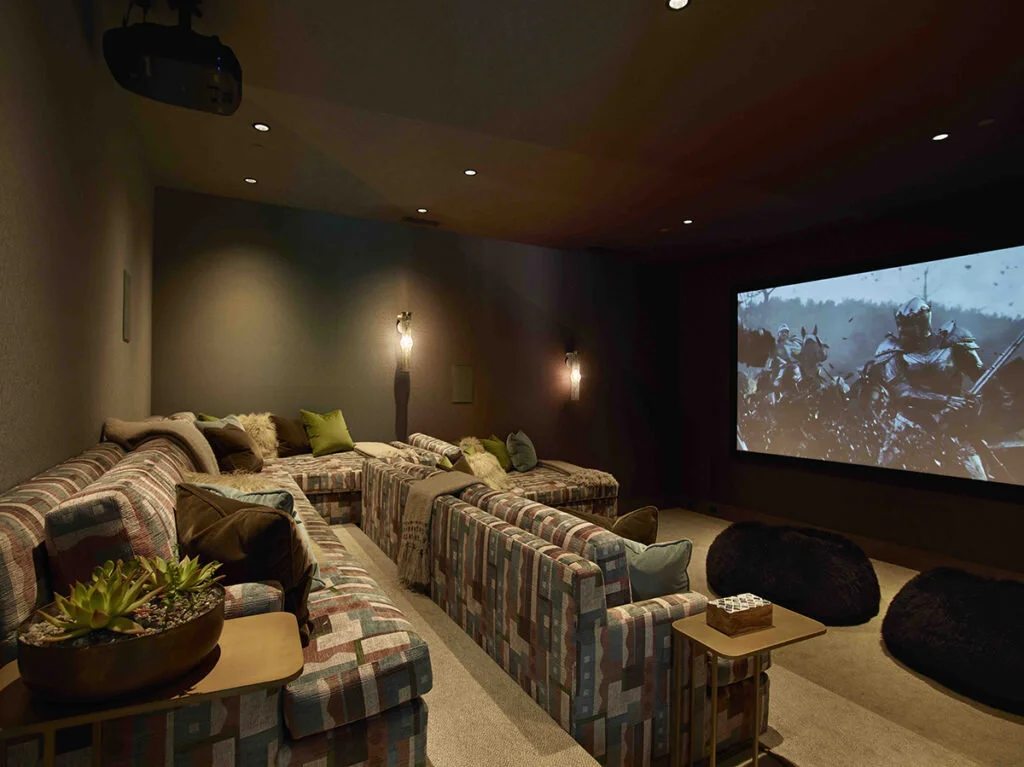 A home theater with a large screen and sofas on multi levels.