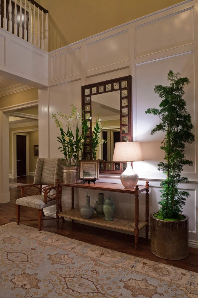 A traditional entryway with a restrained and composed feel uses stained wood against painted panels for an elegant feel.
