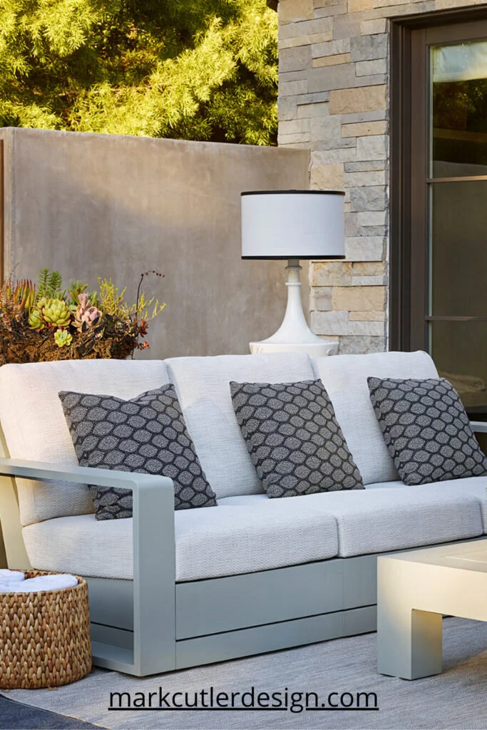 This outdoor space creates a lounge area with a variety of seating options with a clean and contemporary look with a subdued color scheme and modern style aluminum furniture.