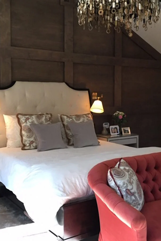 A master bedroom with a jewel tone color palette that adds a level of decoration and interest to the space.