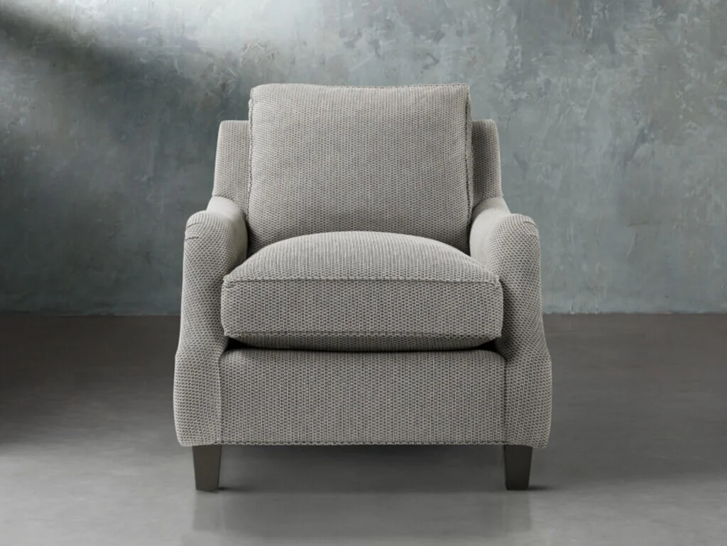 A small scale fully upholstered arm chair is a cozy piece to add to a sitting room.