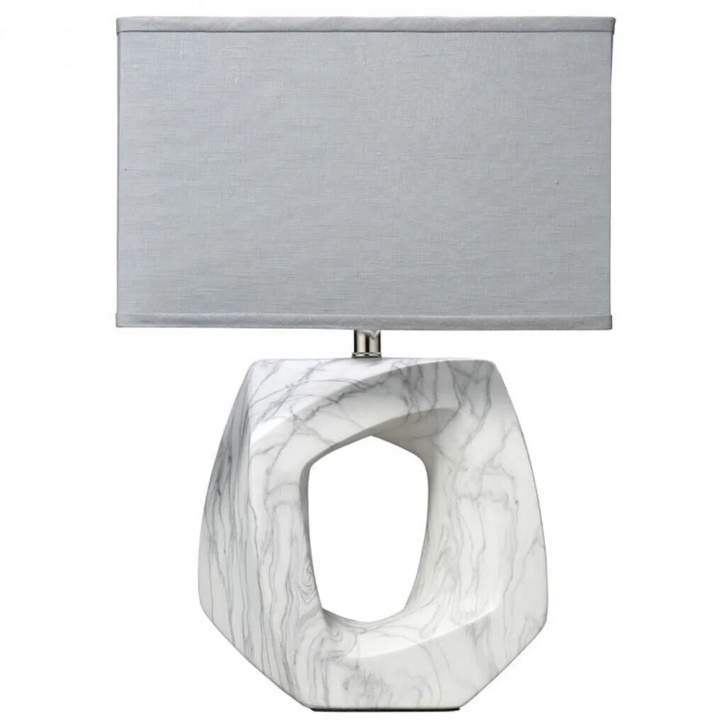 A marble keyhole sculptural lamp with a gray lampshade.