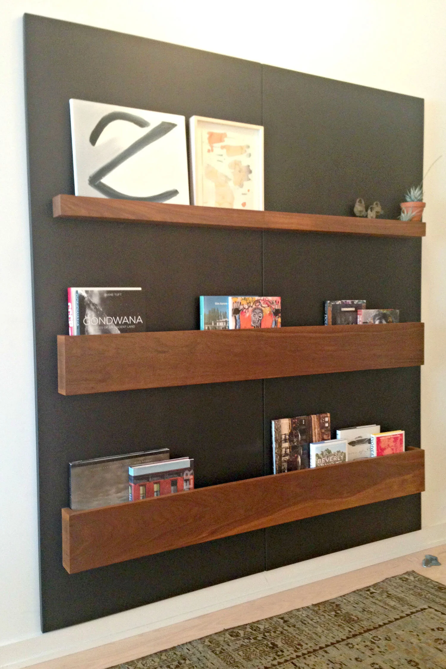 A shallow wood pocket display wall allows book faces to show and works well in a narrow space.